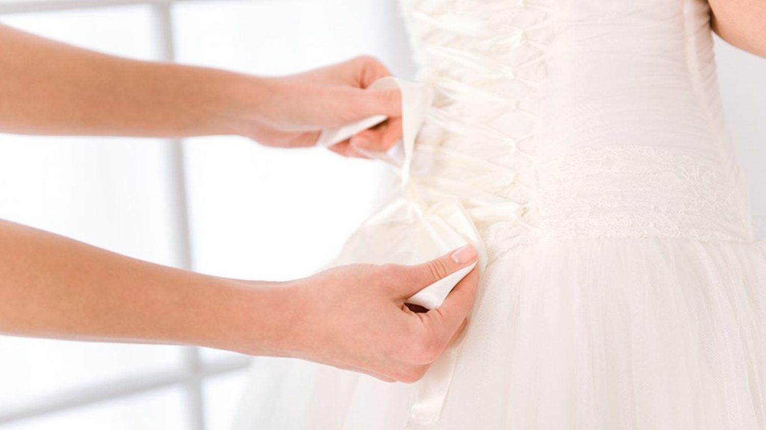 Closeup portrait of a bride putting white wedding dress