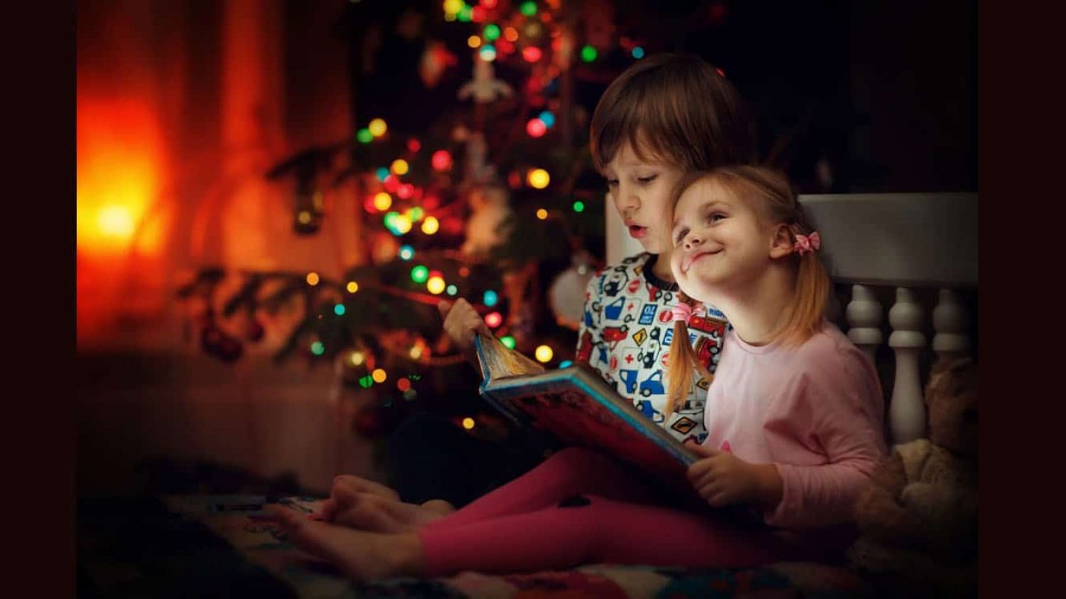 Children reading a book at Christmas